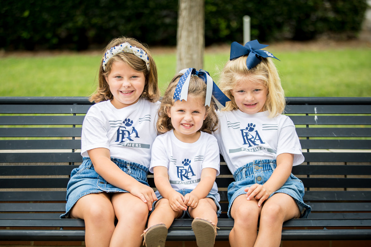 Young girls wearing FRA Spirit Store apparel.