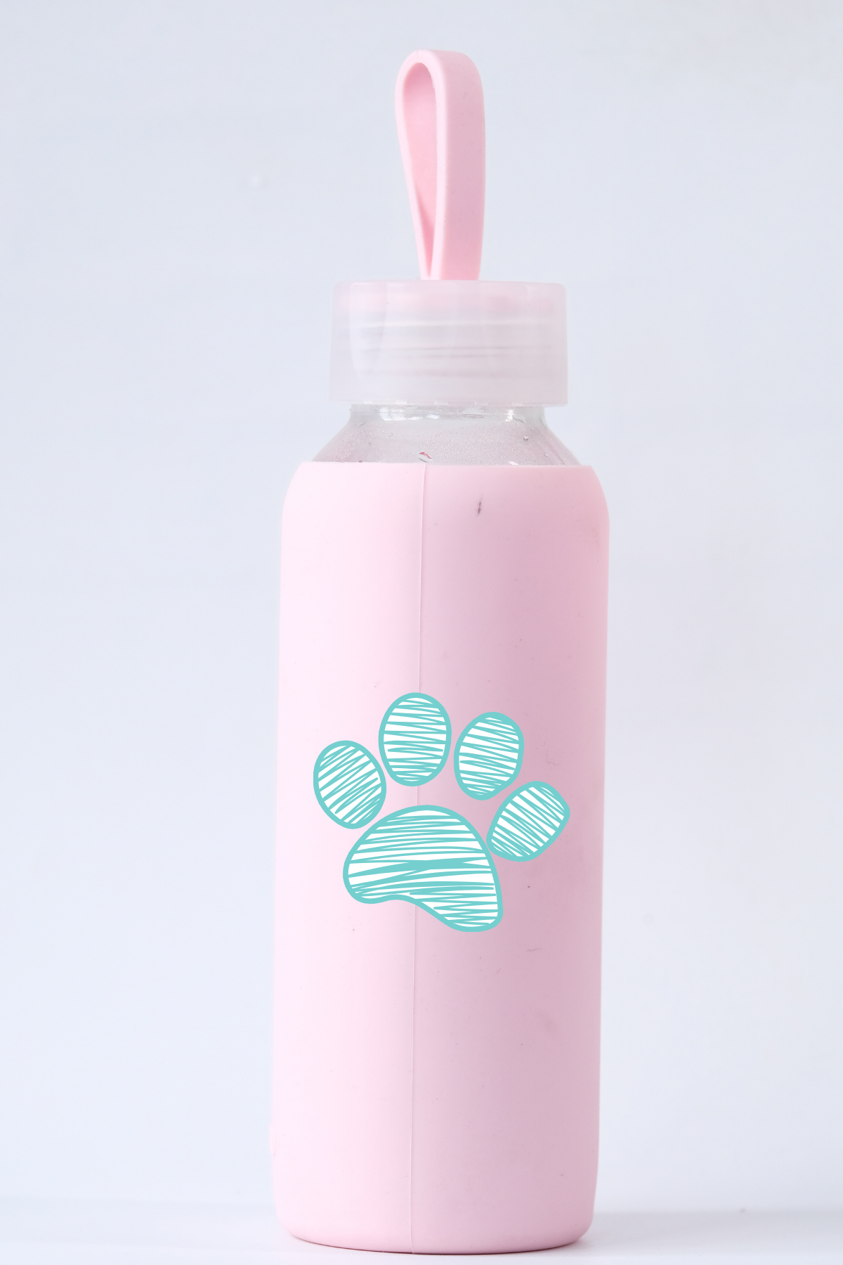 Pink water bottle with a paw print design on a light gray background